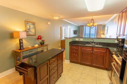 a large kitchen with a sink and a counter at Waterscape C605 - Top Floor Beach Views - Free Beach Service - Interior Facing! in Fort Walton Beach