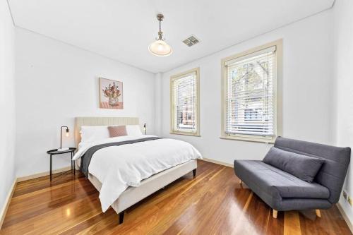 1 dormitorio con 1 cama y 1 silla en Escape To Sydney @ Ultimo Unique 2 Bedroom Sleeping 7 City Side en Sídney