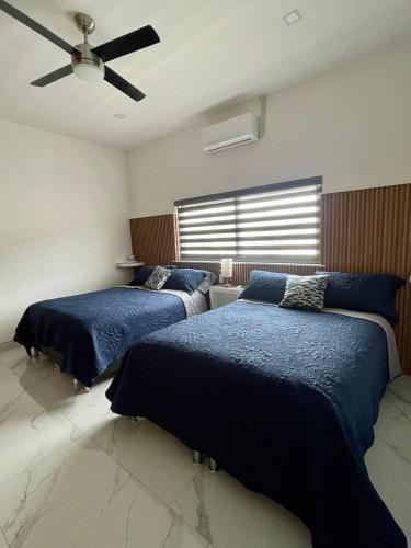 a bedroom with two beds and a ceiling fan at Casa Santacruz in Ensenada