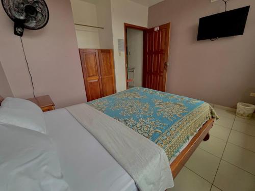 a bedroom with a bed and a flat screen tv at Hotel Río Tena in Tena