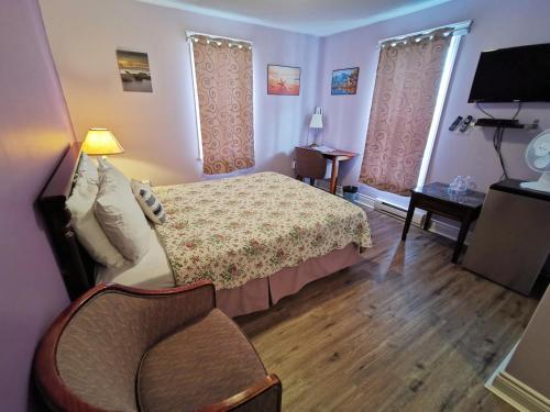 a bedroom with a bed and a chair in it at The Inn at Fisherman's cove in Halifax