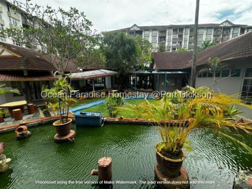 un complexe avec une piscine et un hôtel dans l'établissement Ocean Paradise homestay @ port dickson, à Port Dickson