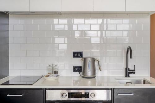 eine Küchentheke mit einer Spüle und einem Mixer in der Unterkunft CBD Apartment beside Millennium in Auckland