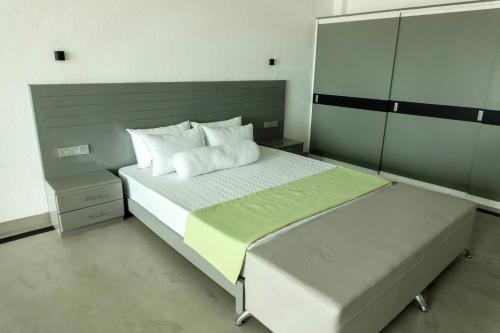 a bedroom with a large bed with two white pillows at Josan Villa with a Glorious Beach and Sea View in Habaraduwa