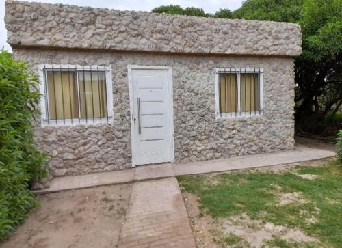 a stone house with a door and two windows at Alquiler playa Quequén in Quequén