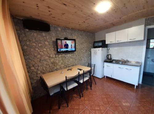 Alquiler playa Quequén في قويقوين: مطبخ مع طاولة وبعض الكراسي وتلفزيون على الحائط