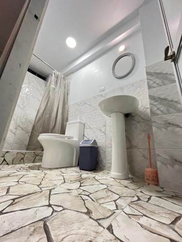 ein Bad mit einem Waschbecken und einem WC in der Unterkunft Mariandes Hostel in Huaraz
