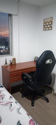 a black office chair sitting in front of a desk at habitacion privada in Bogotá