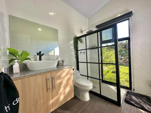 a bathroom with a sink and a toilet and a window at Cabañas y suites Sunset in Alto Boquete