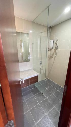een badkamer met een douche en een glazen deur bij Căn hộ hiện đại in Quy Nhon