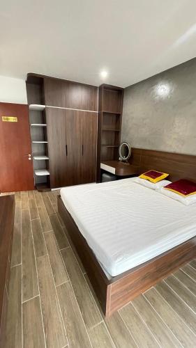 - une grande chambre avec un grand lit et des placards en bois dans l'établissement Căn hộ hiện đại, à Quy Nhơn