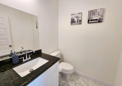 Baño blanco con lavabo y aseo en Centrally Located 3 Bed Minutes From Downtown, en Houston