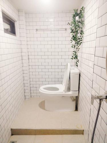 a white bathroom with a toilet with a plant on it at Garmin House 8PAX 3BR in Hatyai Town in Hat Yai