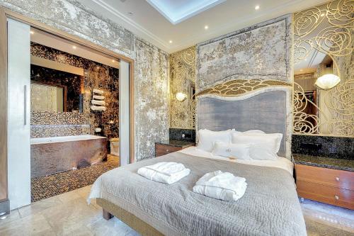 um quarto com uma cama grande e uma banheira em Mała Anglia Deluxe Rooms & SPA em Sopot