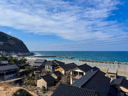 a view of a beach with houses and the ocean at Seaside House Nagi in Itoigawa