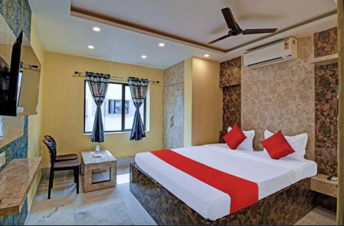 a hotel room with a bed and a desk and a window at Hotel Divine Chariot in kolkata