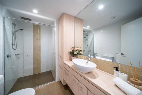 a bathroom with a white sink and a shower at Wattle on Morphett - Central CBD WiFi in Adelaide