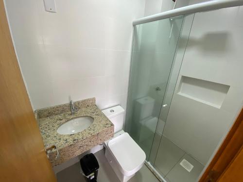 a small bathroom with a sink and a shower at Ótimo apto 50m da areia churrasq 2Q 2 banheiros 301 in Torres