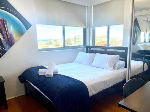 a small bedroom with a bed with a window at Perfect Randwick Escape -2Bdrm-Parking - Walk To Hospital & Shops in Sydney