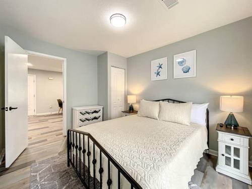a bedroom with a white bed and a hallway at SMV Elegant Beach Home Near Mayo in Jacksonville Beach