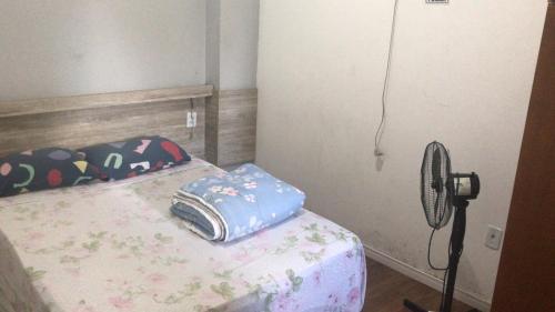 Habitación pequeña con cama y ventilador. en POUSADA ECONOMICA PORTO, en Porto Alegre
