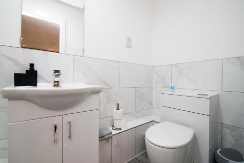 a white bathroom with a toilet and a sink at 1 Bed Heaven Near The Center in Derby