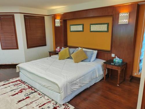 a bedroom with a large white bed with two tables at Port Dickson Teluk Kemang Pantai Tanjung Gemok by 3SIBS in Port Dickson
