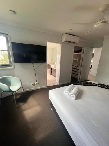 a bedroom with a bed and a chair and a window at at Marina Shores in Airlie Beach