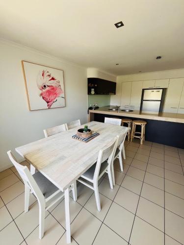 a kitchen with a white table and chairs at at Marina Shores in Airlie Beach