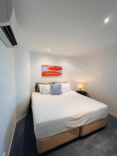a bedroom with a large white bed in a room at at Marina Shores in Airlie Beach