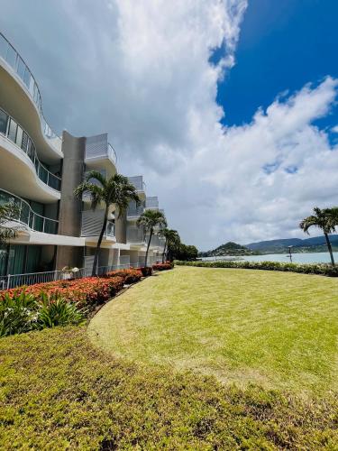 a large building with a lawn in front of it at at Marina Shores in Airlie Beach