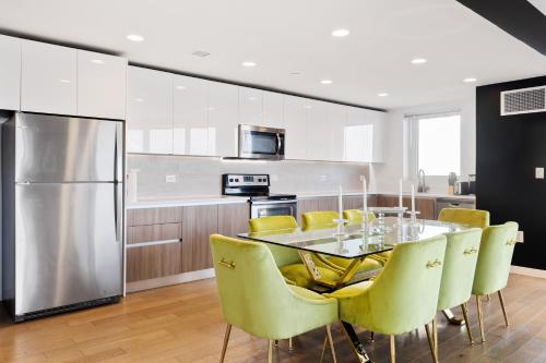cocina con mesa de comedor y sillas amarillas en Tallest Penthouse in NJ with Wraparound Balcony, en Hoboken