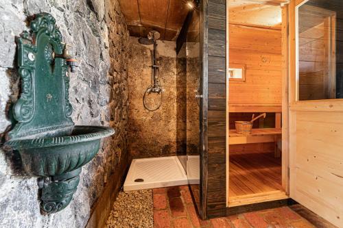 Baño de piedra con lavabo verde y ducha en Vineyard Cottages Skatlar - Happy Rentals en Otočec