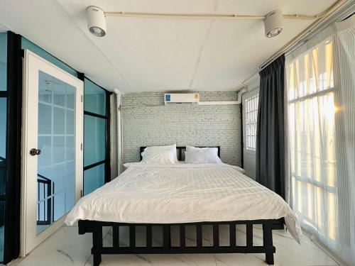 a bedroom with a large bed with white sheets at Chubby 9 in Bang O