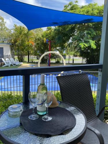 a table with two glasses and a bottle of wine at BIG4 Mackay Blacks Beach Holiday Park in Mackay