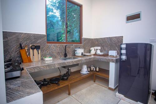 a kitchen with a counter with a sink and a window at D2 Villa Unawatuna in Galle