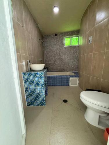a bathroom with a toilet and a sink and a tub at Terraza del Lago in Tequesquitengo