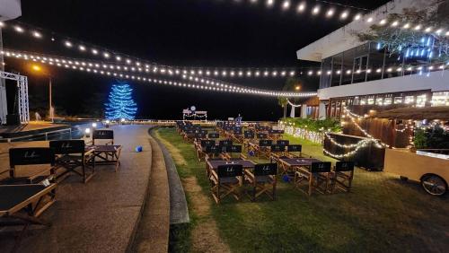 a restaurant with tables and chairs and a christmas tree at Blu Hotel in Nakhon Phanom