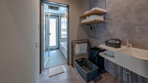 a bathroom with a shower and a sink and a mirror at WAT RESORT 焚火とサウナBBQandリゾートヴィラ 高山 in Takayama