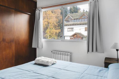- une chambre avec un lit et une grande fenêtre dans l'établissement Rivendell Bungalows Bariloche, à San Carlos de Bariloche