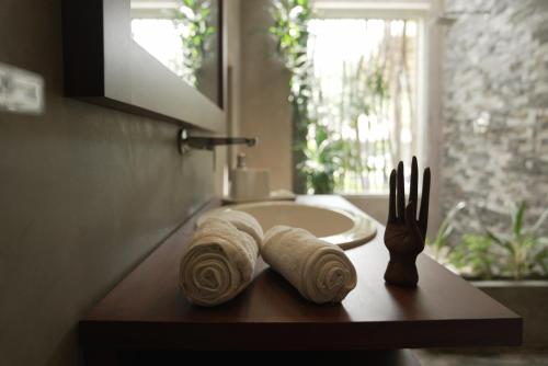 a bathroom sink with towels and a fork on a table at Shiva Sunrise Resort in Hikkaduwa