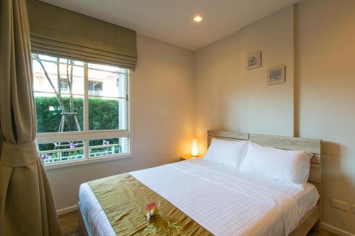 a bedroom with a bed and a window at Autumn Condo in Hua Hin