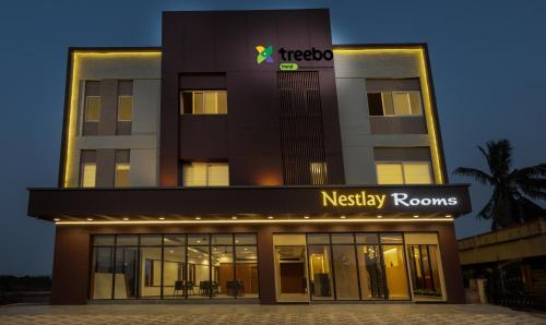 a night view of a hotel with a nashley rooms sign at Treebo Nestlay Rooms Gummidipoondi in Chennai