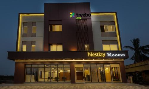 a night view of a hotel with a nashley rooms sign at Treebo Trend Nestlay Rooms Gummidipoondi in Chennai