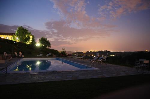 a swimming pool with a sunset in the background at Agriturismo Bricco San Giovanni in Isola d'Asti