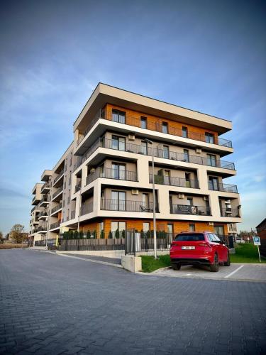 a red car parked in front of a building at Premium Apartament & Spa in Zator