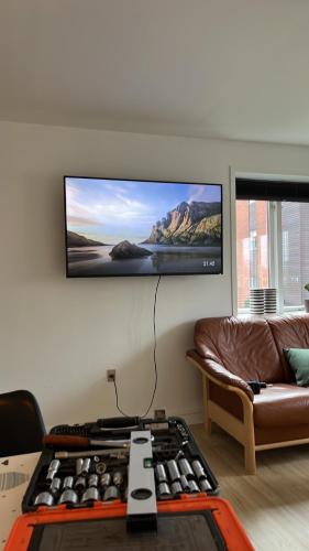 a living room with a couch and a flat screen tv at Casa Home of Bricks - Downtown Holidays in Billund