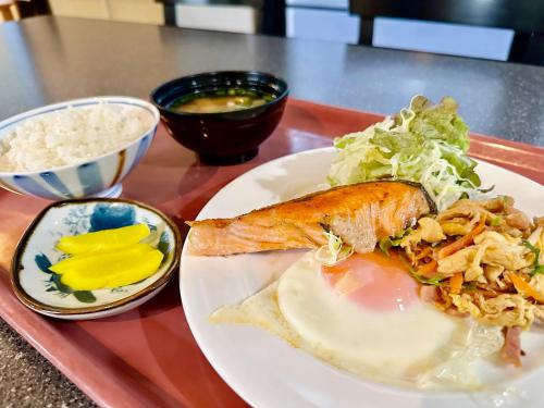 a plate of food with a sandwich and salad on a tray at Hotel Happy Holiday Ishigaki in Ishigaki Island
