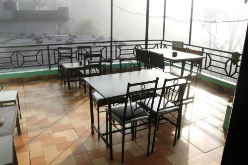 um restaurante com mesas e cadeiras numa varanda em Yours Family Restaurant and Homestay em Deorāli