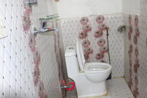 uma casa de banho com um WC branco numa cabina em Yours Family Restaurant and Homestay em Deorāli